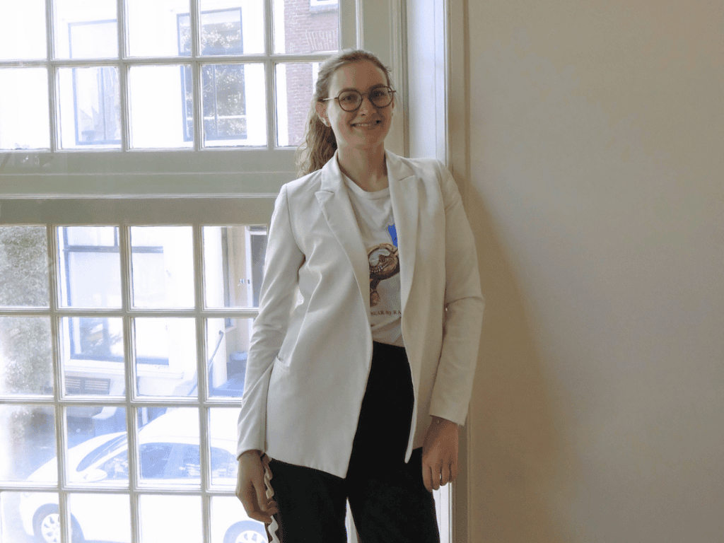 Maud, employee of review tracking, leaning against a wall